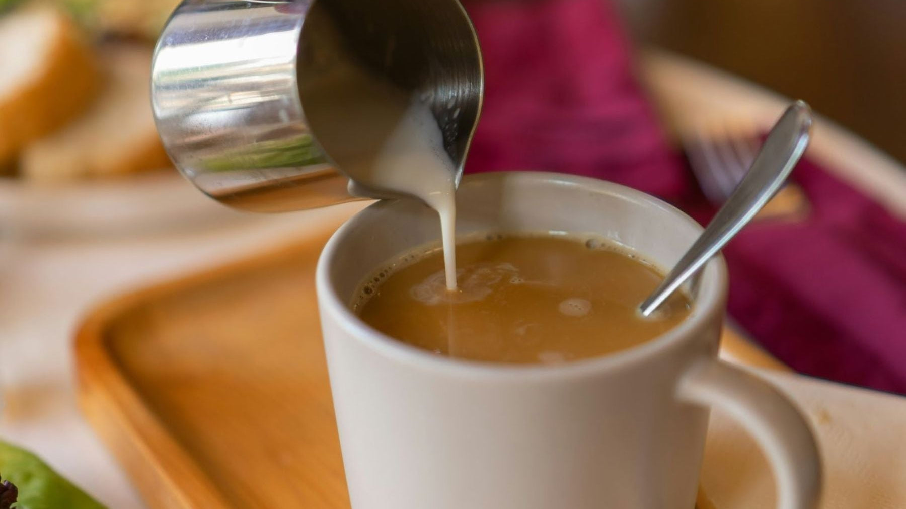 Milk being poured into earl grey tea