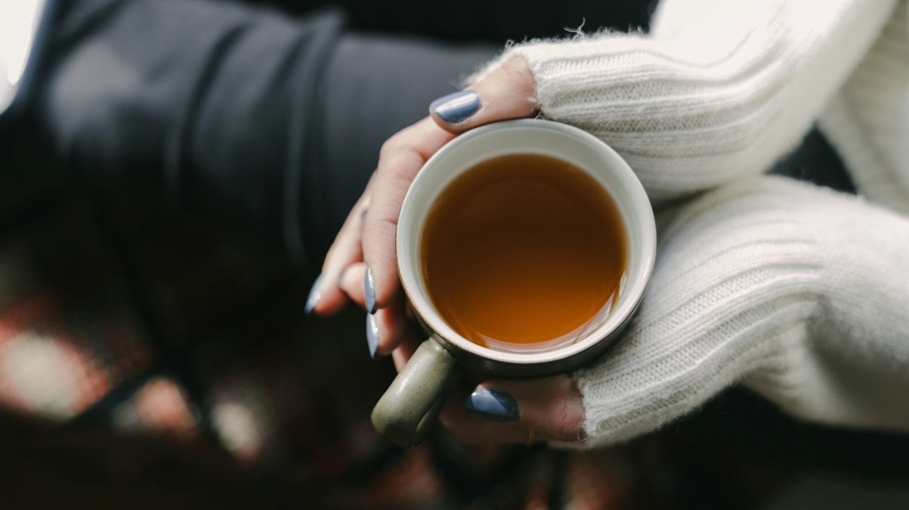 A hand holding a cup of Tea
