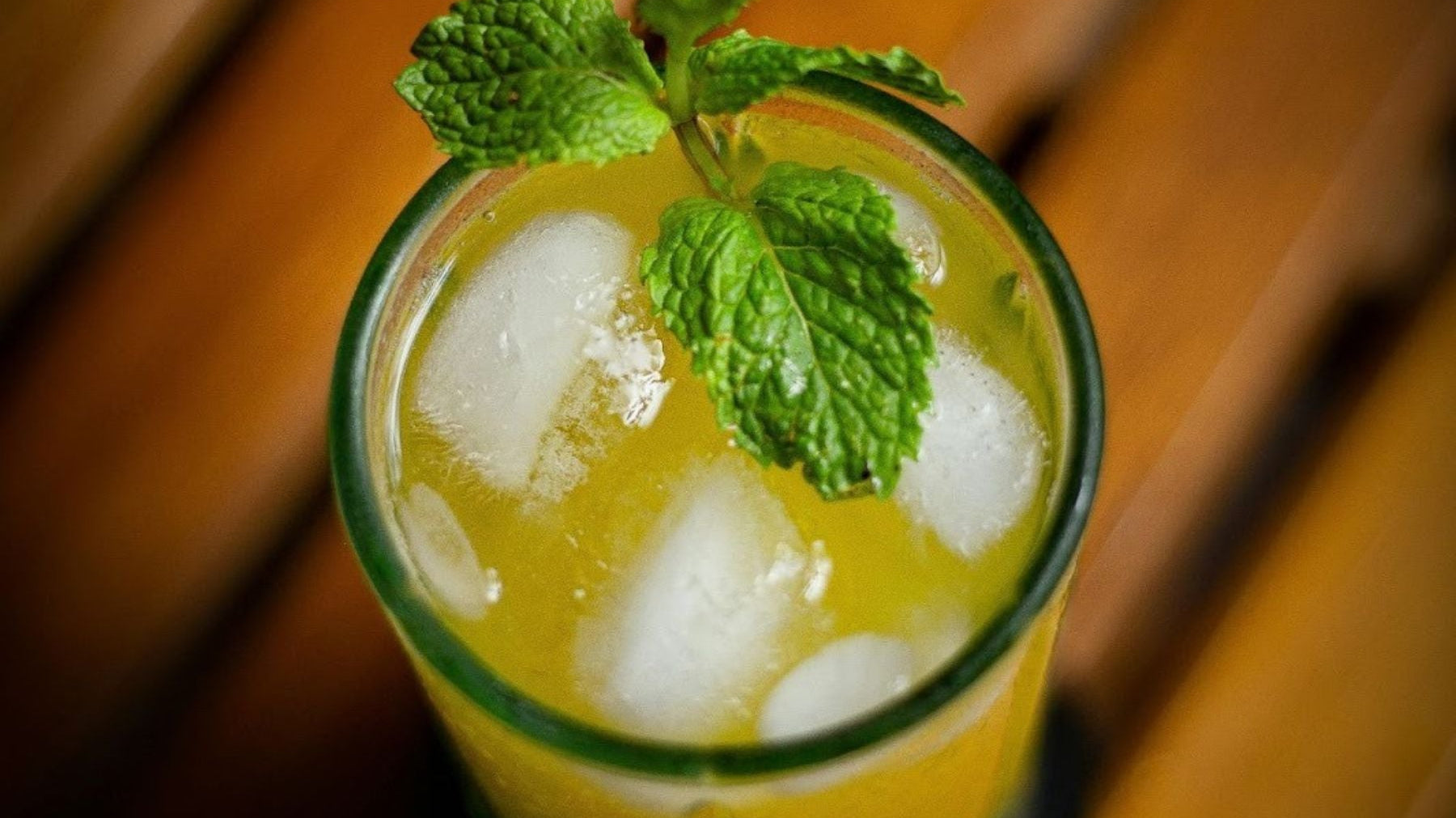 Iced lemon tea with slices and mint in a tall glass
