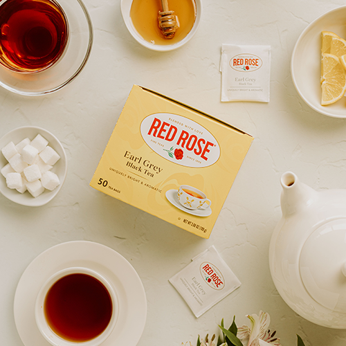 Red Rose Earl Grey Tea Bags at a tea table with sugar cubes, honey, and lemon slices