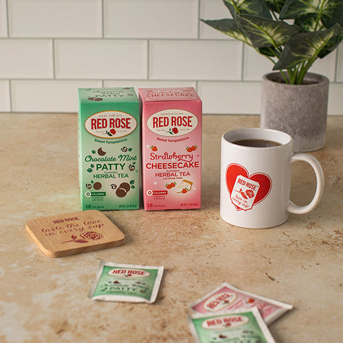 Red Rose tea packaging and a mug on a kitchen counter with a plant in the background.