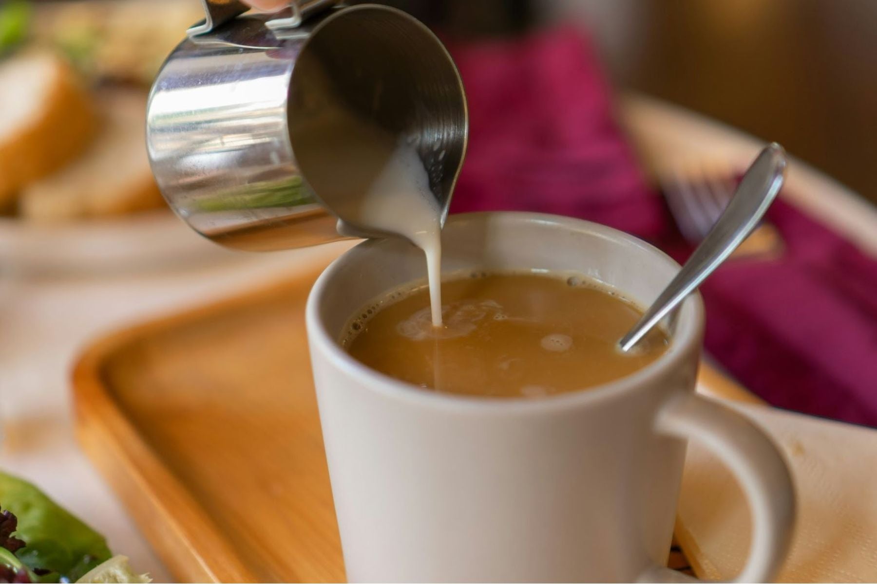 Milk being poured into earl grey tea