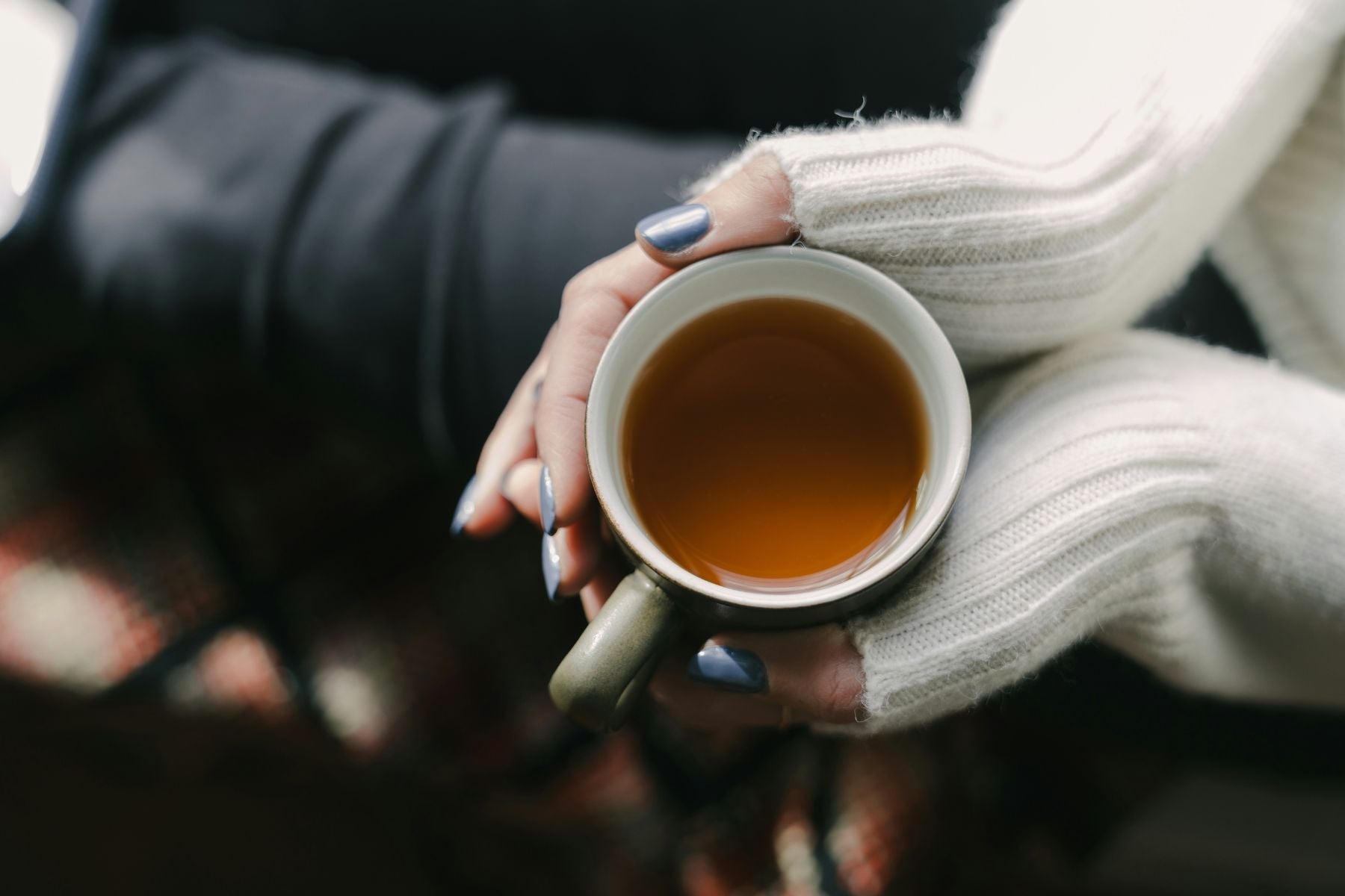 A hand holding a cup of Tea