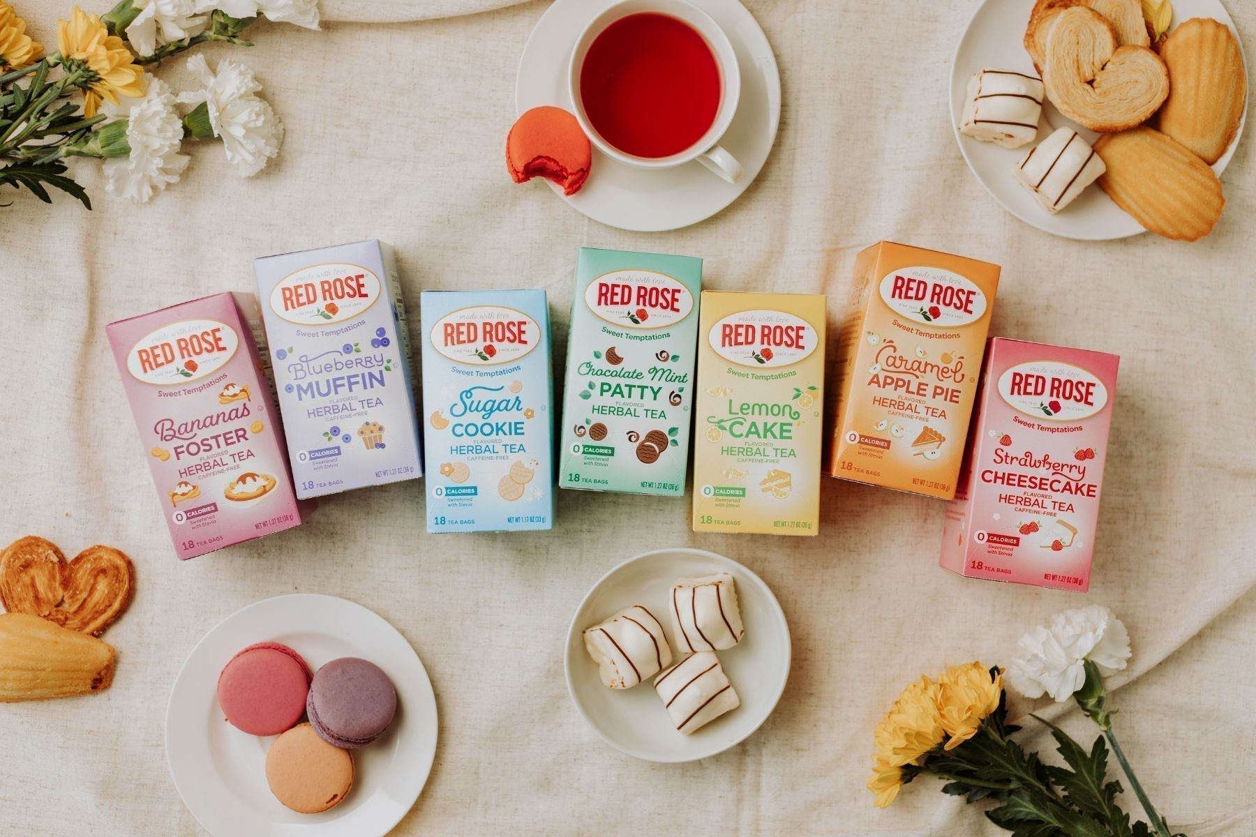 Red Rose dessert tea collection with pastries, macarons, and tea cups