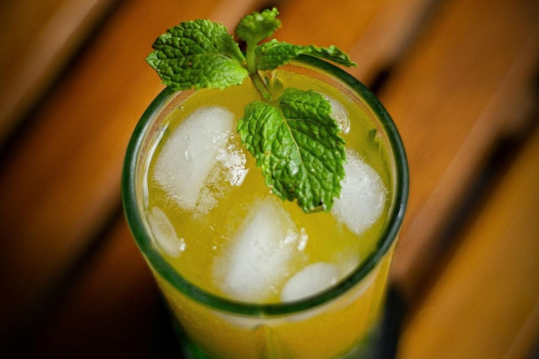 Iced lemon tea with slices and mint in a tall glass