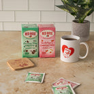 Red Rose tea packaging and a mug on a kitchen counter with a plant in the background.