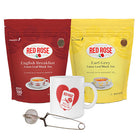 2 Red Rose loose tea packages, mug with heart design, and tea strainer on a white background
